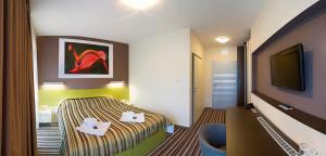 a hotel room with a bed and a flat screen tv at Hotel Air in Holíč