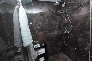 a bathroom with a shower with a black marble wall at Joumaya Luxury Gauthier in Casablanca