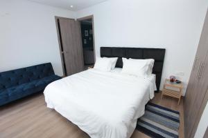 カサブランカにあるJoumaya Luxury Gauthierのベッドルーム(白い大型ベッド1台、青いソファ付)