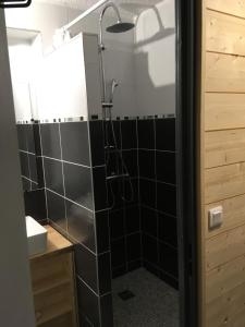 a bathroom with a shower with a black tiled wall at Studio 4 personnes fraichement rénové au pied des pistes à Valfréjus in Valfréjus