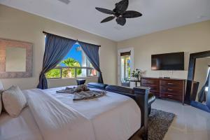 a bedroom with a large bed with a ceiling fan at Villa Nagashima Beautiful Luxury Villa in Palm Desert