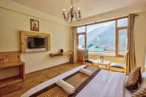 Una habitación de hotel con una cama y una ventana grande. en HOTEL WILD ROSE, en Jagatsukh