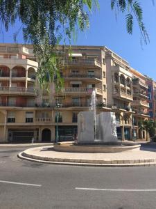un grand bâtiment avec une fontaine en face d'un bâtiment dans l'établissement Appartamento in centro a Mentone vicino alla spiaggia Parcheggio privato INCLUSO!, à Menton