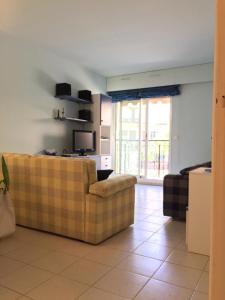 ein Wohnzimmer mit einem Sofa und einem TV in der Unterkunft Appartamento in centro a Mentone vicino alla spiaggia Parcheggio privato INCLUSO! in Menton
