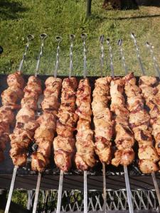 a bunch of skewered meat cooking on a grill at Aglonas Līdakas in Priežmale