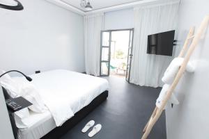 a bedroom with a bed and a tv and a ladder at Joumaya Blue Manoir in Casablanca