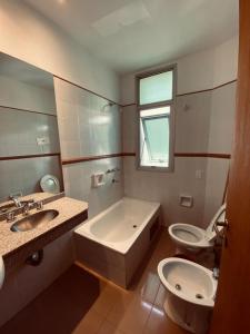 łazienka z wanną, toaletą i umywalką w obiekcie Hotel Riviera w Córdobie