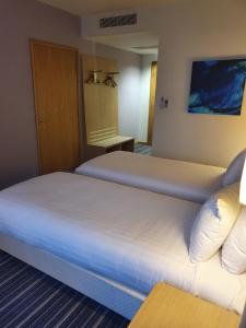 a hotel room with two beds and a couch at Holiday Inn Express Rotherham - North, an IHG hotel in Rotherham