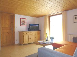 a living room with a couch and a tv and a table at Haus Meinecke in Bad Hindelang