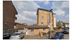 a brick building with cars parked in a parking lot at London Zone 2 Lovely 4 bedroom Apartment - 3 Trowbridge Road in London