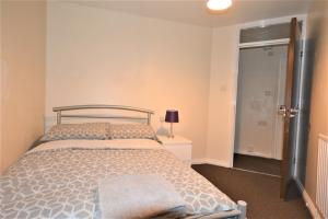 a bedroom with a bed and a door with a lamp at London Zone 2 Lovely 4 bedroom Apartment - 3 Trowbridge Road in London