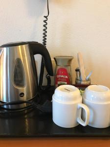una encimera con 2 tazas de café y tostadora en Hotel Korning Kro en Korning
