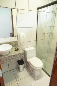 a bathroom with a toilet and a sink at Hotel BR 364 in Cacoal