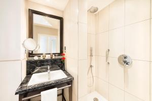 a white bathroom with a sink and a shower at The Bailey's Hotel London Kensington in London