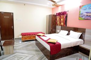 um quarto com uma cama num quarto com paredes cor-de-rosa em Devansh Bhanu Residency DBR em Srikalahasti
