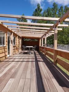 a wooden deck with a table and a pergola at Resort Land & Zee in Scharendijke