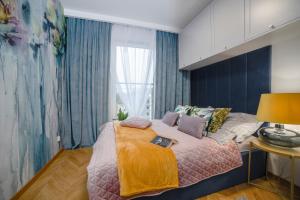 Un dormitorio con una cama grande y una ventana en Apartament Warmiński by RENT4YOU, en Olsztyn