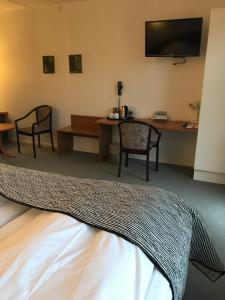 Cette chambre comprend un lit, une table et des chaises. dans l'établissement Hotel Korning Kro, à Korning