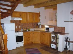 una cocina con armarios de madera y electrodomésticos blancos en Chata Ala, en Demänovská Dolina
