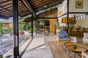 an open living room with a kitchen and dining room at Villa Kanan, Secluded Jungle Paradise in Selong Belanak
