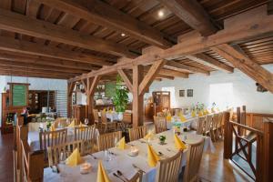ein Esszimmer mit Tischen und Stühlen und Holzdecken in der Unterkunft Zur Goldenen Kartoffel in Prötzel