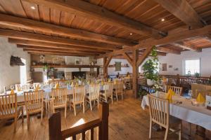 ein Restaurant mit Holzdecken und Tischen und Stühlen in der Unterkunft Zur Goldenen Kartoffel in Prötzel