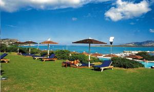 a group of chairs and umbrellas next to a pool at Cala Rosa Club Hotel in Stintino