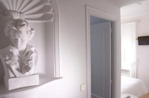 a bust of a woman on a wall next to a mirror at Hostal Boreal Mistral in Burgos