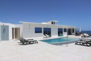 a villa with a swimming pool and a house at Villa Ozeano in Costa Calma