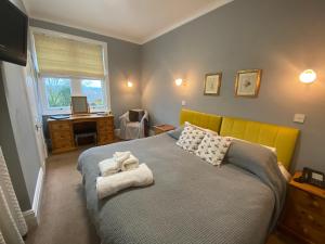1 dormitorio con 1 cama con cabecero amarillo y ventana en The Old Manse Pickering, en Pickering