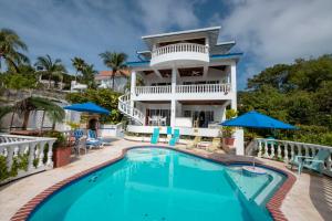 una casa grande con piscina frente a ella en APARTAMENTOS TT9, en San Andrés