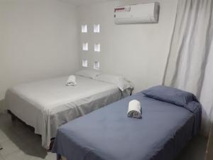 2 Betten in einem kleinen Zimmer mit Heizung in der Unterkunft Thelmar Rooms Cancun in Cancún