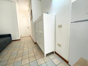 Habitación con armario blanco y suelo de baldosa. en Il Viaggiatore Serapo, en Gaeta