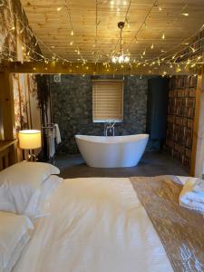 a large bathroom with a tub and a window at Roe Lodge at Owlet Hideaway - with Hot Tub, Near York in Seaton Ross