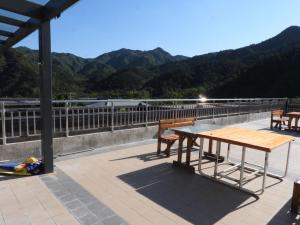 a picnic table on a roof with mountains in the background at Beijing Huanghuacheng Water Great Wall Derunju Guesthouse in Huairou