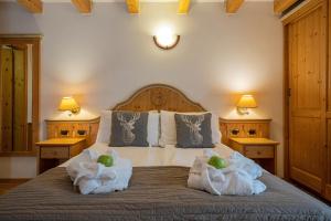 a bedroom with a bed with towels on it at Hotel Soreghes Gran Chalet in Campitello di Fassa