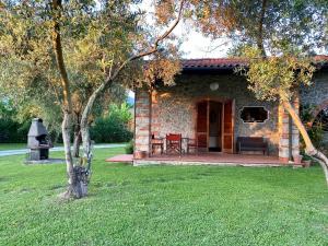uma casa de pedra com um alpendre e um grelhador em Perfetta per la Famiglia em Pietrasanta