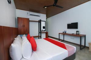 a bedroom with a bed with red and white pillows at The Domain in Piliyandala
