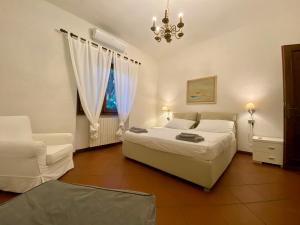um quarto com uma cama, uma cadeira e um lustre em Perfetta per la Famiglia em Pietrasanta