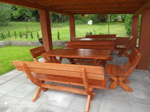 une table en bois et des bancs sur une terrasse dans l'établissement Ubytovanie Luky, à Bojnice