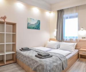 ein Schlafzimmer mit einem Bett mit zwei Handtüchern darauf in der Unterkunft For You Apartmanok in Eger
