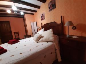 1 dormitorio con 1 cama con sábanas y almohadas blancas en Apartamentos Rurales Esencias De La Alcarria, en Hueva