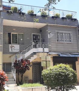 una casa con una escalera blanca delante de ella en The Sugar Cane Hostel, en Medellín