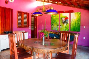 a dining room with a wooden table and purple walls at Casa FLOREAL Icaraizinho de Amontada wifi in Icaraí