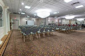 a conference room with chairs and a whiteboard in a room at Red Roof PLUS Newark Liberty Airport - Carteret in Carteret