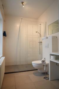 a white bathroom with a toilet and a shower at Focus Hotel in Kortrijk