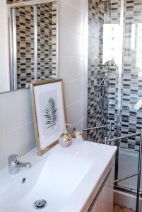 bagno con lavandino bianco e specchio di Casas de Mar - Casa Estrela do Mar a Olhão