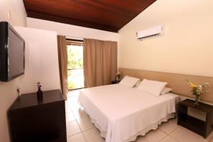 une chambre d'hôtel avec un lit et une télévision dans l'établissement Sun Bay Pipa Hotéis, à Pipa