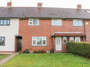 a red brick house with a white door at Beechview in Foxt