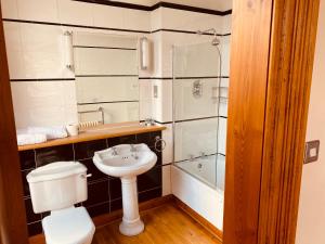 a bathroom with a toilet and a sink and a shower at The Redstones Hotel & Restaurant in Glasgow